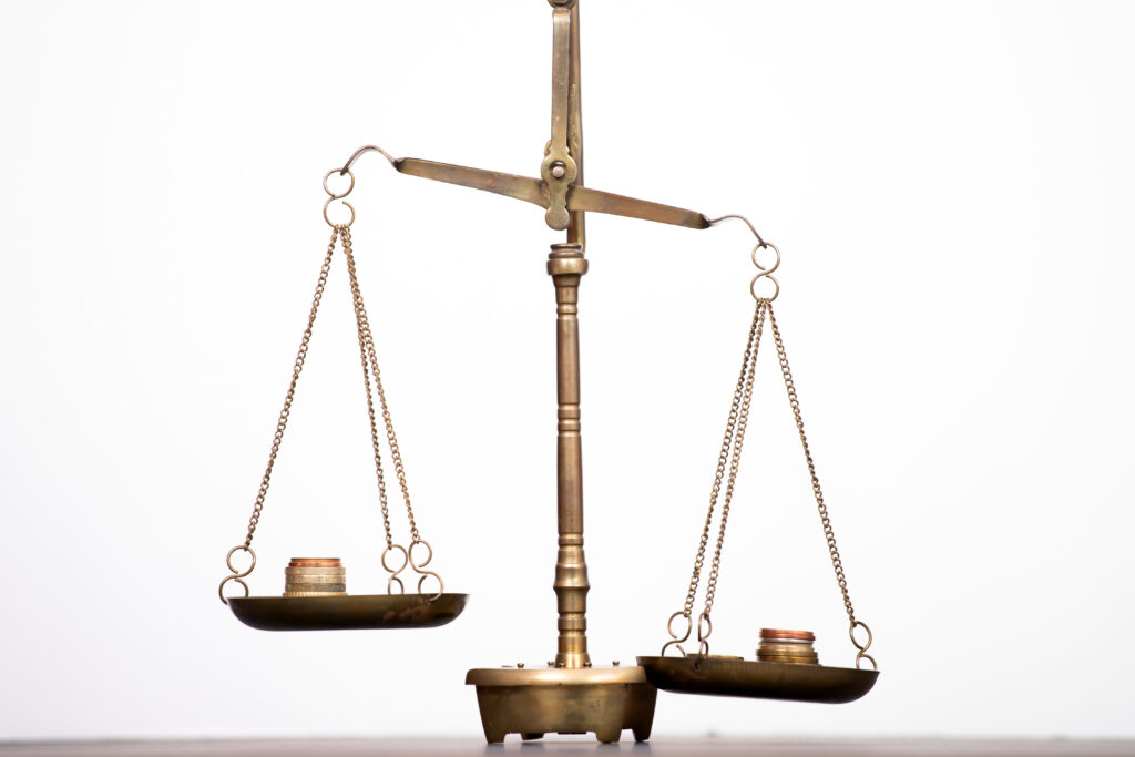 A pair of old fashioned scales offers a visual representation of weighing up the pros and cons of outsourced HR for SMEs